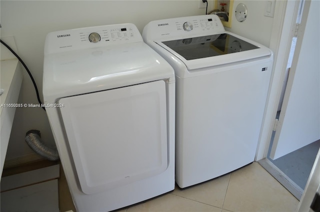 laundry area with independent washer and dryer and light tile patterned floors