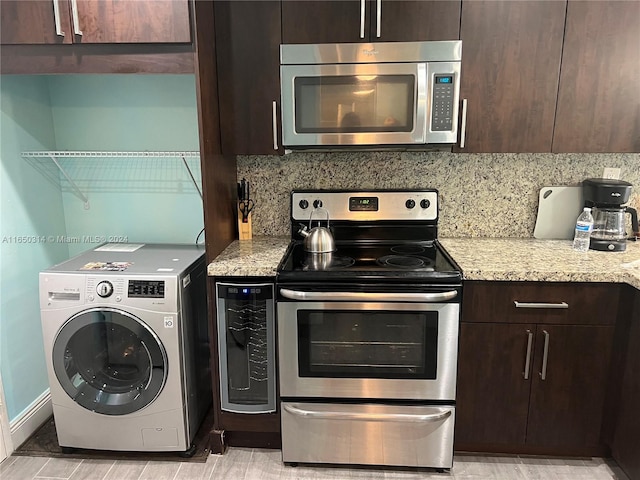 kitchen featuring dark brown cabinets, light stone countertops, decorative backsplash, washer / dryer, and appliances with stainless steel finishes