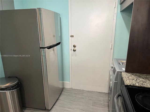 kitchen with light wood-type flooring and stainless steel refrigerator