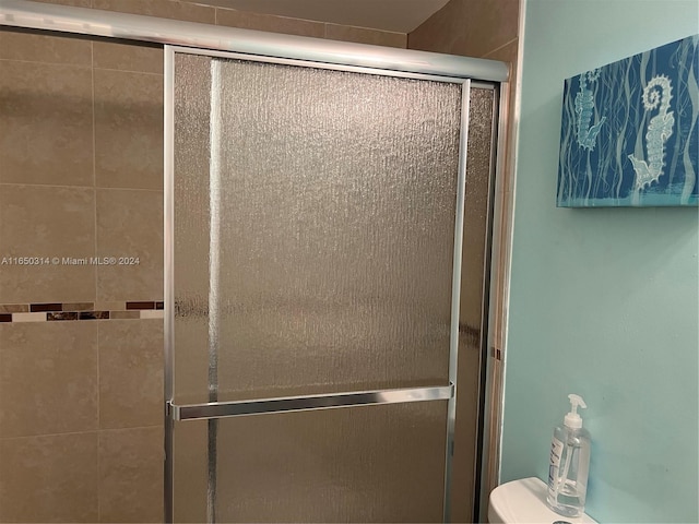 bathroom featuring toilet and an enclosed shower