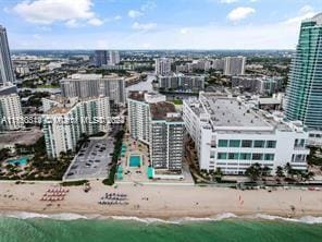 birds eye view of property with a beach view and a water view