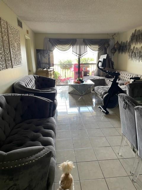 living room featuring a textured ceiling and tile patterned floors