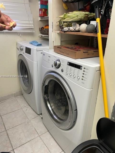 laundry area featuring washing machine and clothes dryer and light tile patterned flooring