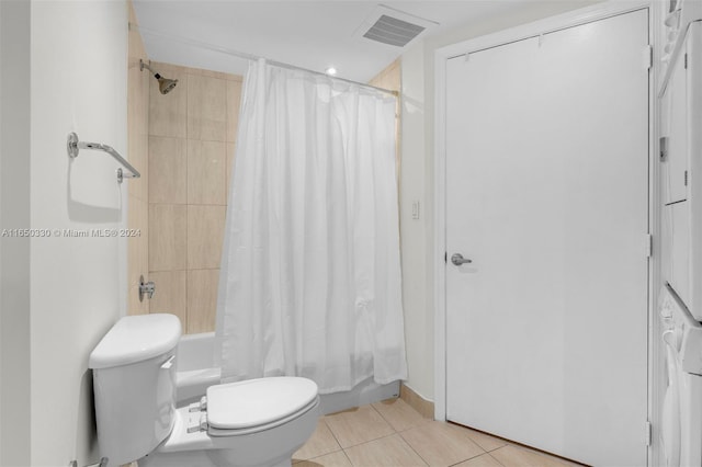 bathroom featuring toilet, shower / tub combo with curtain, and tile patterned floors