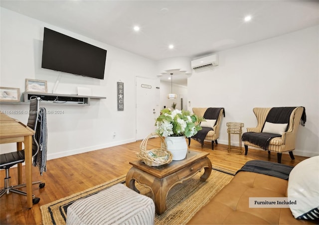 living room with an AC wall unit and light hardwood / wood-style flooring