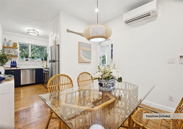 dining area with light hardwood / wood-style floors and a wall mounted air conditioner