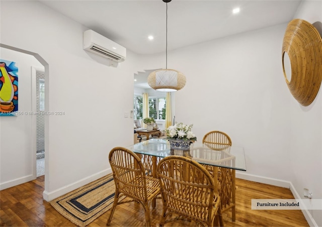 dining room with a wall mounted AC and wood-type flooring