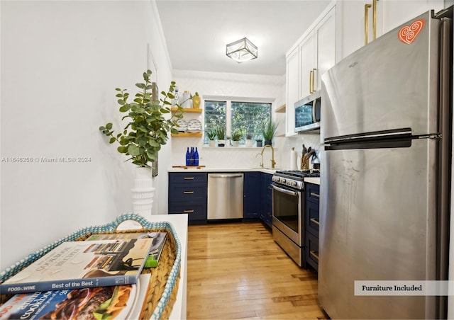 kitchen featuring light wood-type flooring, crown molding, stainless steel appliances, decorative backsplash, and blue cabinets