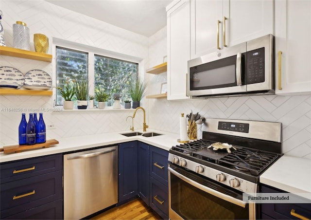 kitchen with white cabinetry, stainless steel appliances, sink, and tasteful backsplash