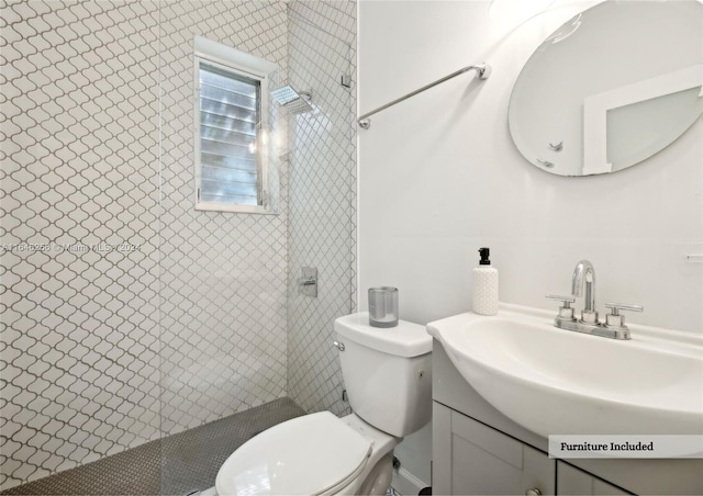 bathroom featuring tiled shower, vanity, and toilet