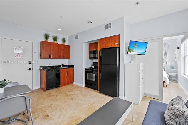 kitchen featuring black appliances, sink, and light tile patterned flooring