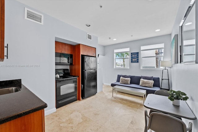 kitchen with black appliances, light tile patterned floors, and sink