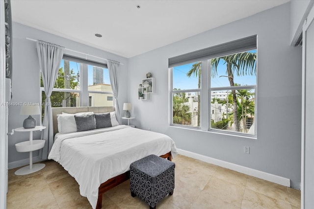 bedroom with light tile patterned floors and multiple windows