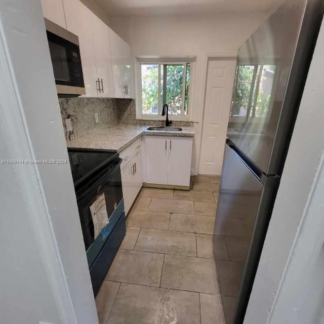 kitchen featuring white cabinetry, sink, decorative backsplash, appliances with stainless steel finishes, and light tile patterned flooring