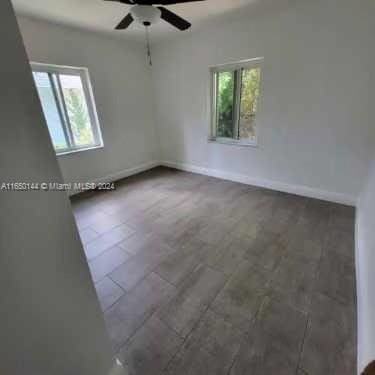 empty room with ceiling fan and hardwood / wood-style flooring