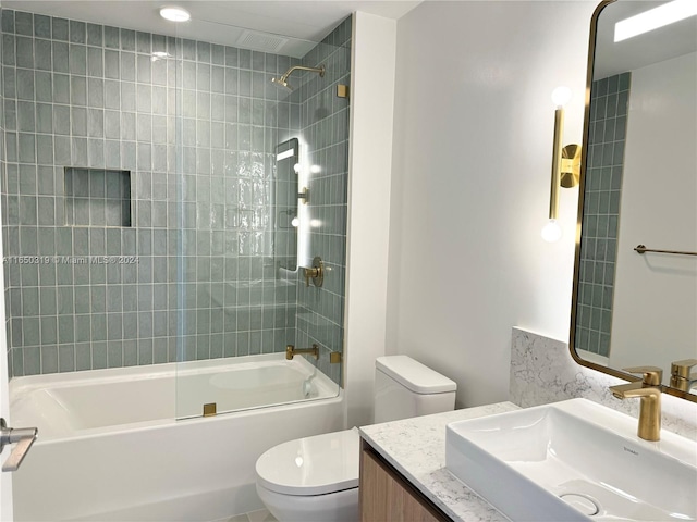 full bathroom featuring tiled shower / bath, toilet, and vanity