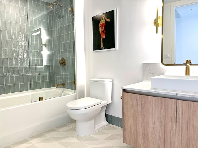 full bathroom featuring tiled shower / bath combo, vanity, toilet, and tile patterned floors