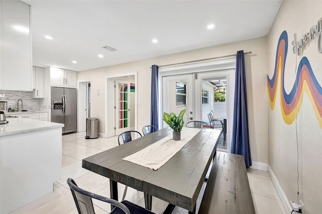 dining room featuring french doors, light tile patterned floors, and sink