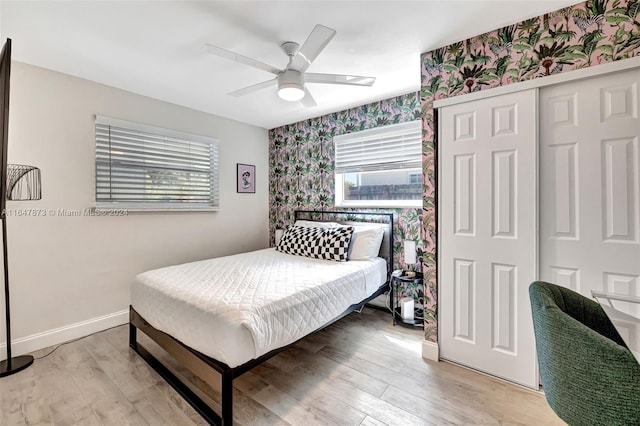 bedroom featuring ceiling fan, a closet, and light wood-type flooring