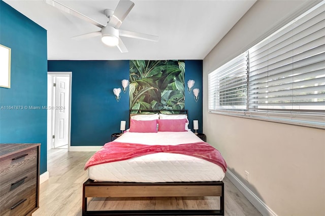 bedroom featuring multiple windows, ceiling fan, and light hardwood / wood-style floors