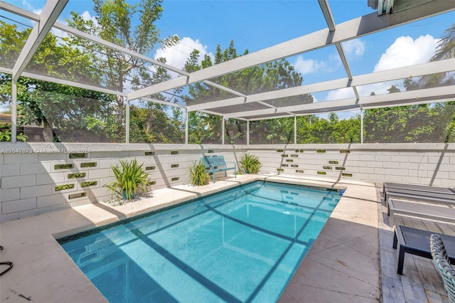 view of pool featuring glass enclosure and a patio area