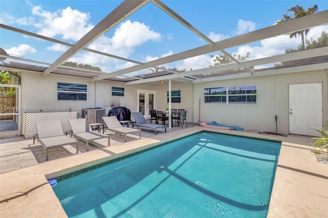 view of pool with a patio area, central air condition unit, and a lanai