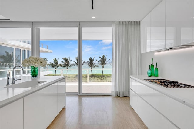 kitchen with light countertops, modern cabinets, a sink, and white cabinets