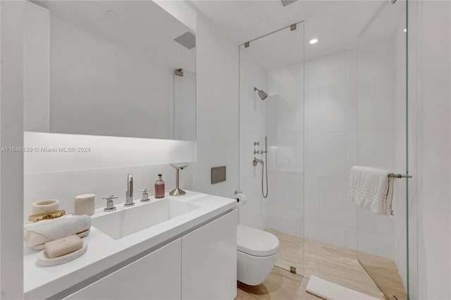 bathroom with a shower stall, toilet, and vanity