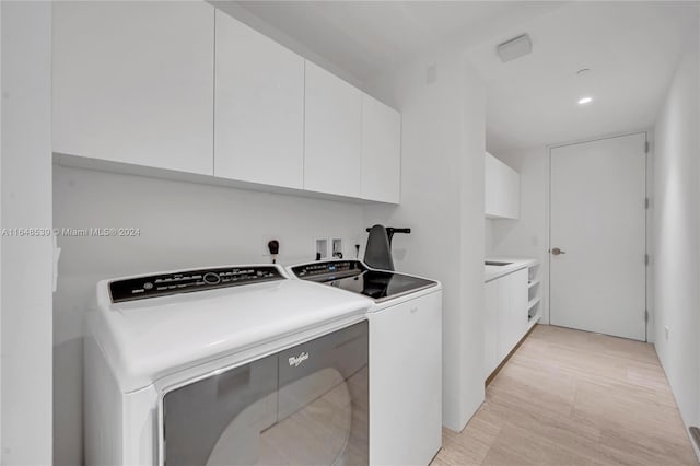 washroom featuring separate washer and dryer and cabinet space