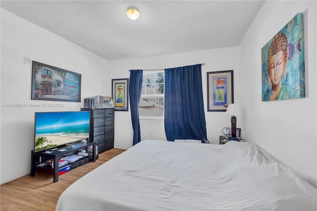 bedroom featuring a textured ceiling and wood-type flooring