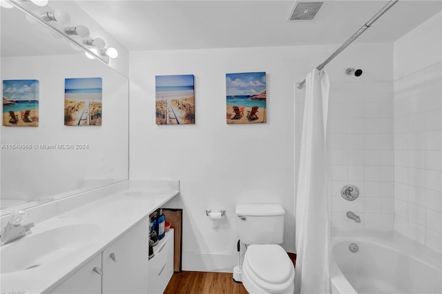 full bathroom featuring vanity, hardwood / wood-style floors, shower / tub combo, and toilet