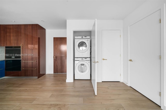 interior space with light hardwood / wood-style floors and stacked washing maching and dryer