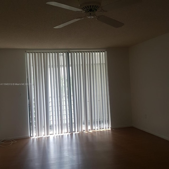 spare room featuring a textured ceiling, a healthy amount of sunlight, ceiling fan, and hardwood / wood-style floors