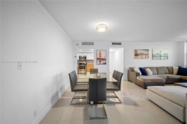 dining room with a textured ceiling and light tile patterned floors