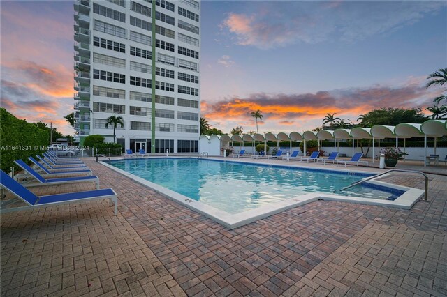 pool at dusk with a patio area