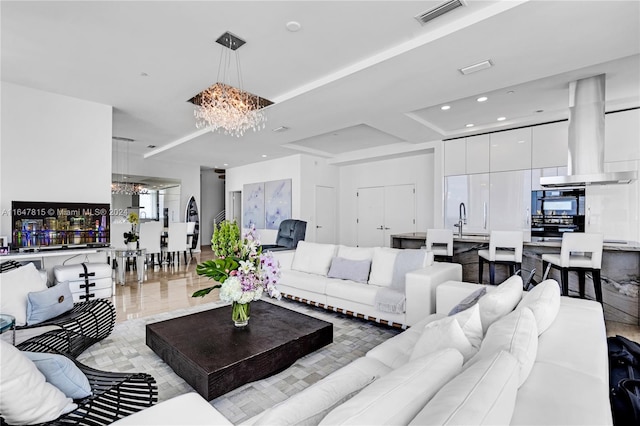 living room featuring a chandelier and sink