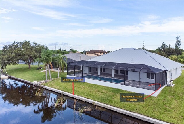 back of house with a water view, a yard, and glass enclosure