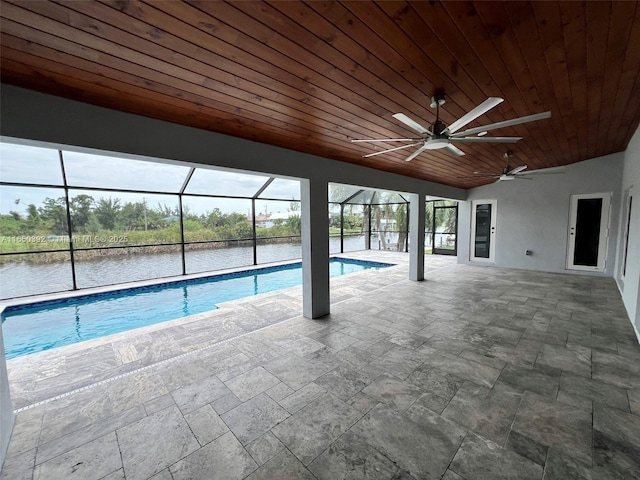 view of swimming pool with a water view, ceiling fan, glass enclosure, and a patio area