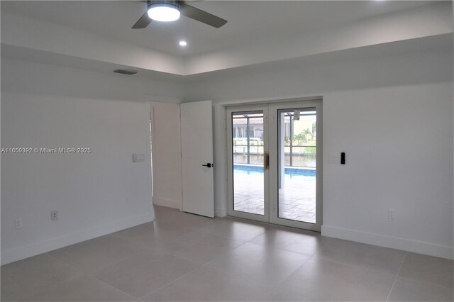 spare room with ceiling fan and tile patterned flooring