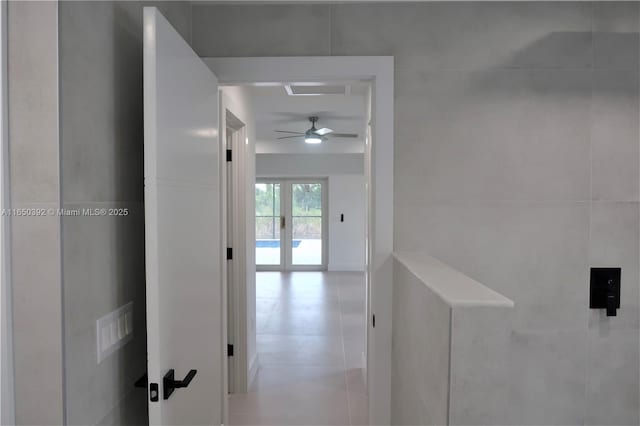 hallway featuring tile walls and french doors