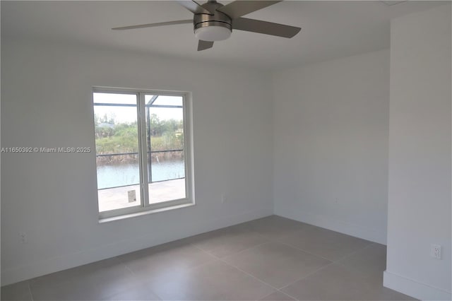 tiled empty room with a water view and ceiling fan