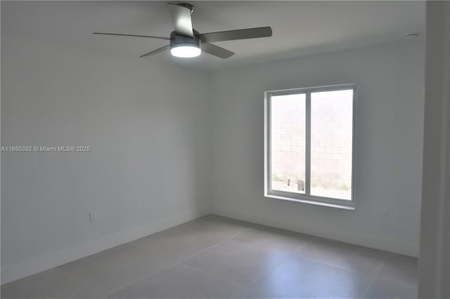 tiled spare room featuring ceiling fan