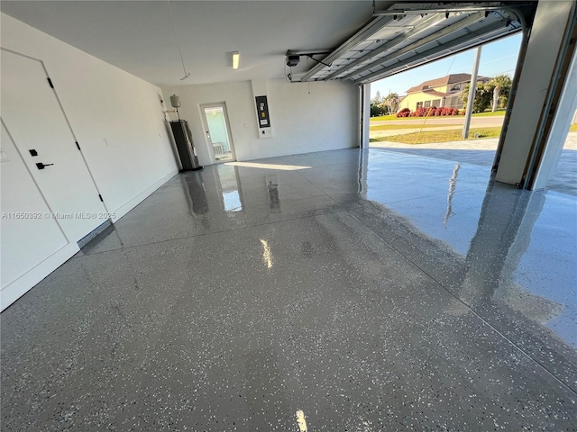 garage with a garage door opener, electric panel, and water heater