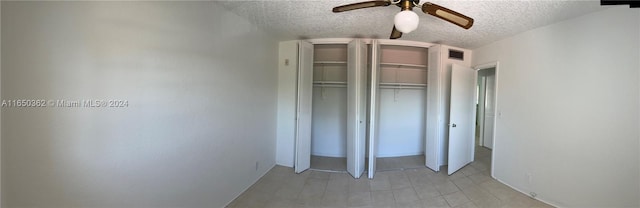 unfurnished bedroom with a closet, ceiling fan, light tile patterned flooring, and a textured ceiling