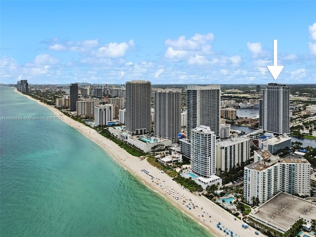 birds eye view of property featuring a beach view and a water view