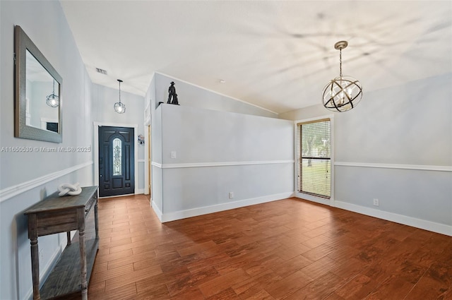 foyer entrance featuring lofted ceiling, a notable chandelier, and hardwood / wood-style floors