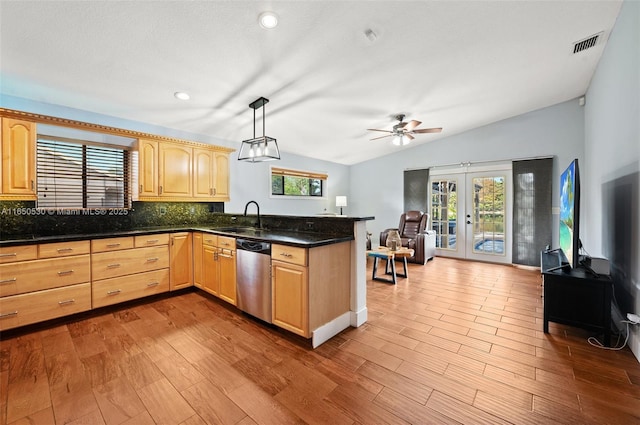 kitchen with sink, lofted ceiling, french doors, stainless steel dishwasher, and pendant lighting