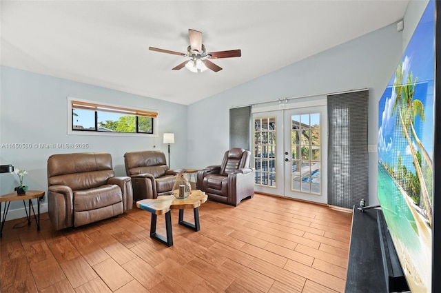 living room featuring light hardwood / wood-style floors, ceiling fan, french doors, and lofted ceiling