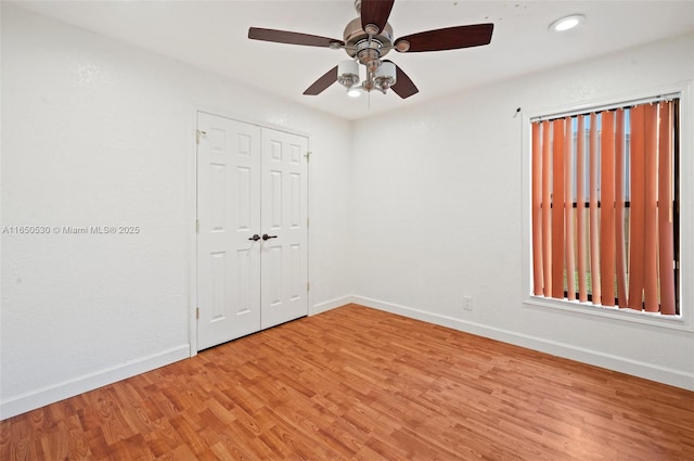 unfurnished bedroom featuring ceiling fan, a closet, and hardwood / wood-style flooring