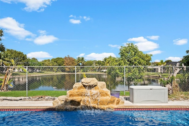 view of pool featuring a hot tub and a water view